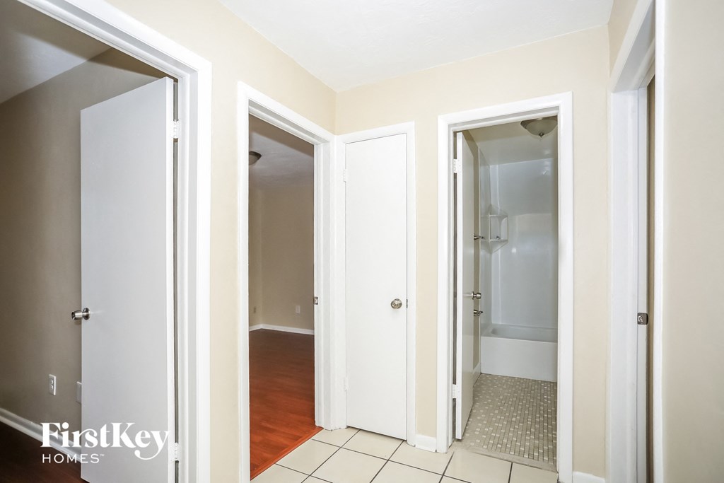 a bathroom with two closets and a door to a hallway