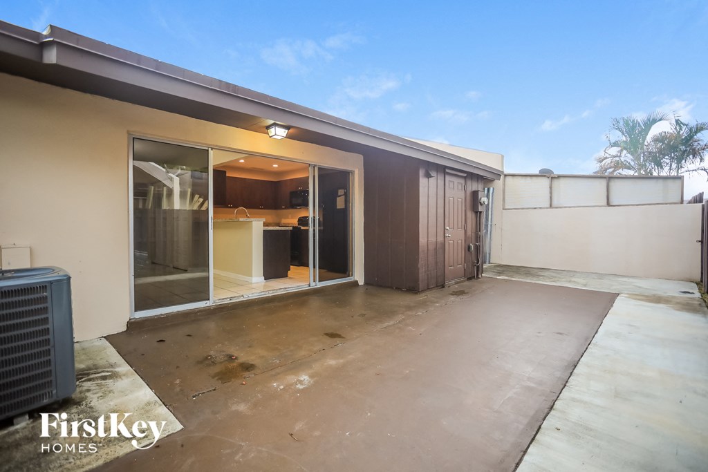 a patio in front of a house with the door open
