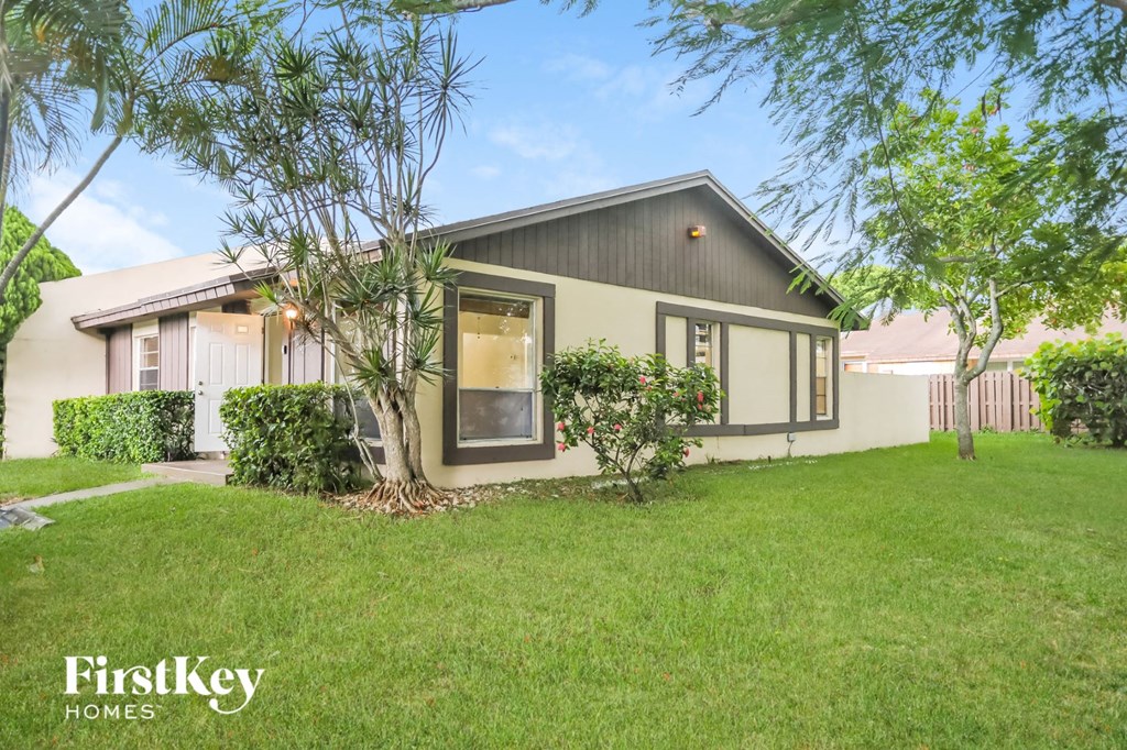 a home with a green lawn and a white house