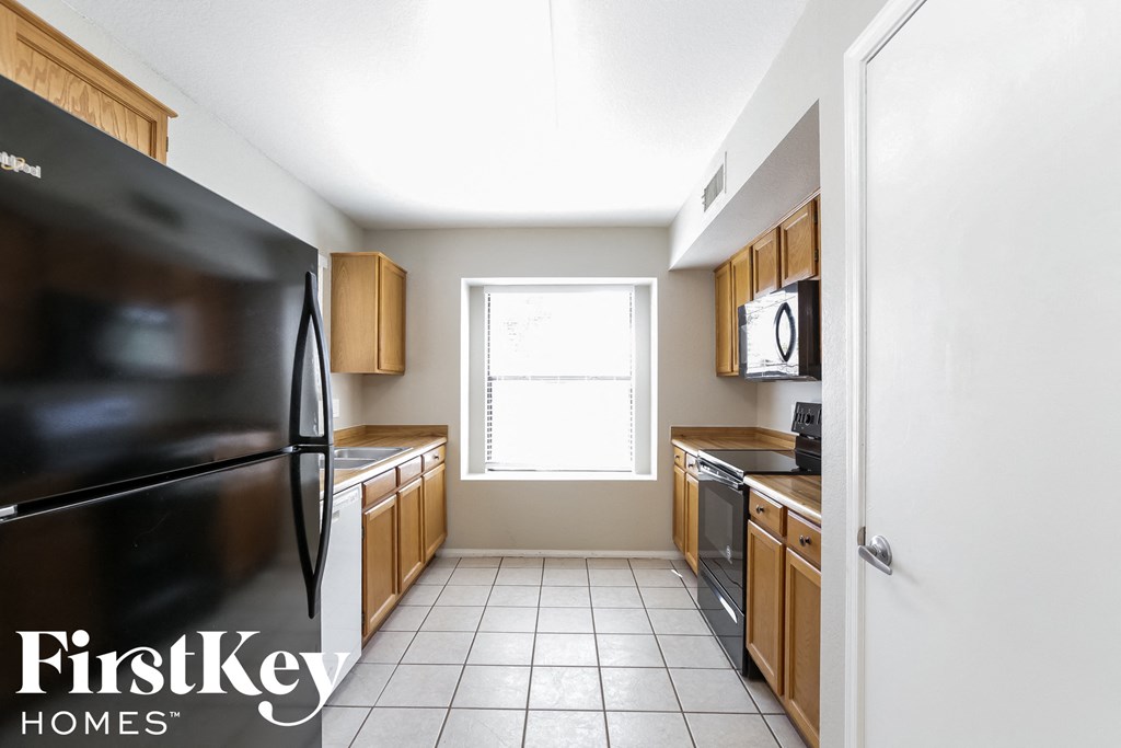 a kitchen with wooden cabinets and stainless steel appliances and a window