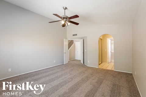 a living room with carpet and a ceiling fan