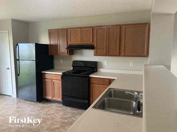 A kitchen with black appliances and wooden cabinets.