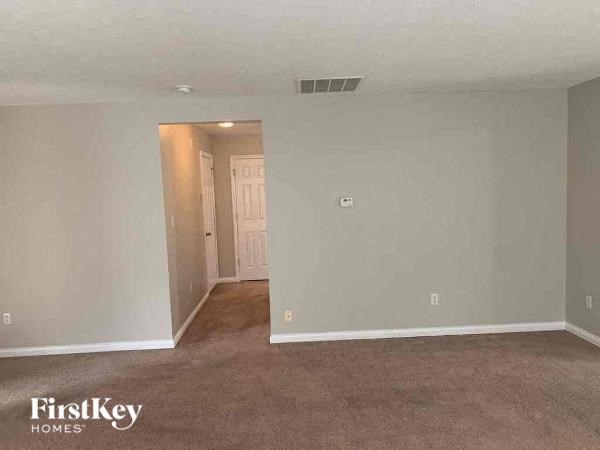 A room with a carpeted floor and a doorway leading to another room.