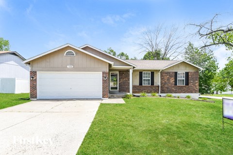 a home with a white garage door and a lawn