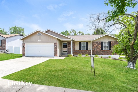 a home with a lawn and a white garage door