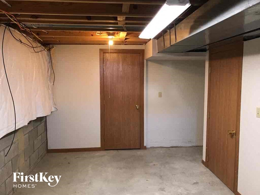 an empty basement with a closet and a door