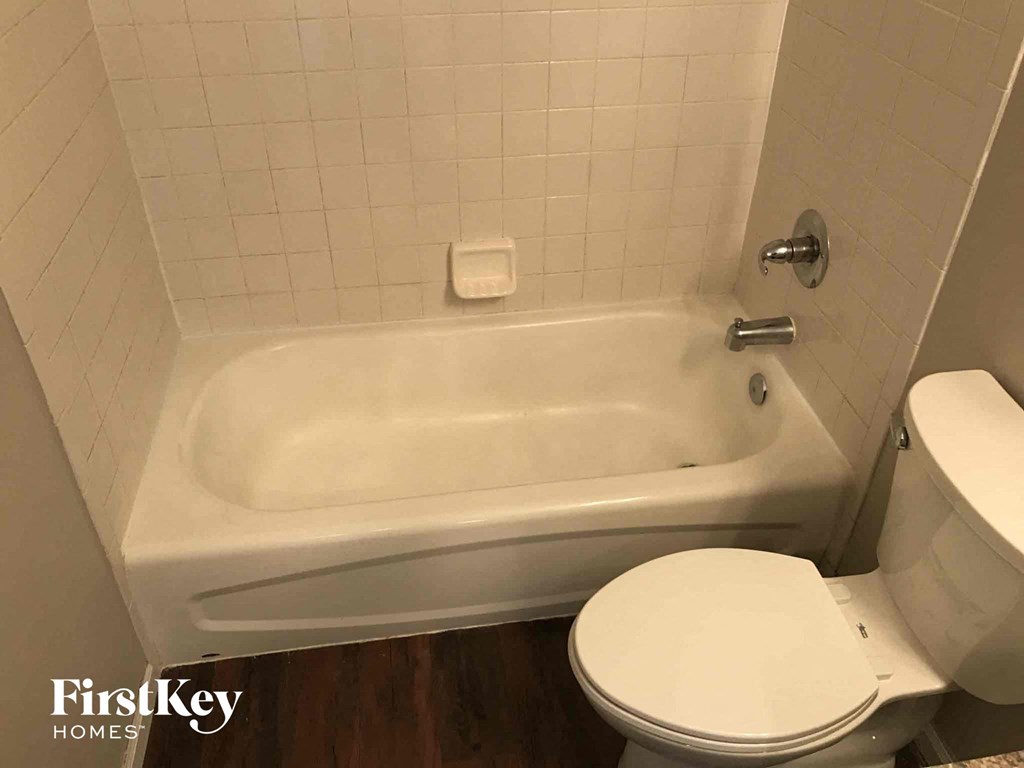 a small bathroom with a toilet and a bath tub