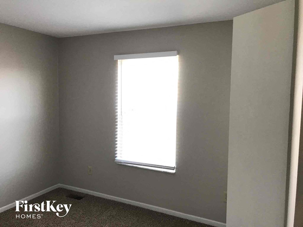 a small room with a window and a white wall