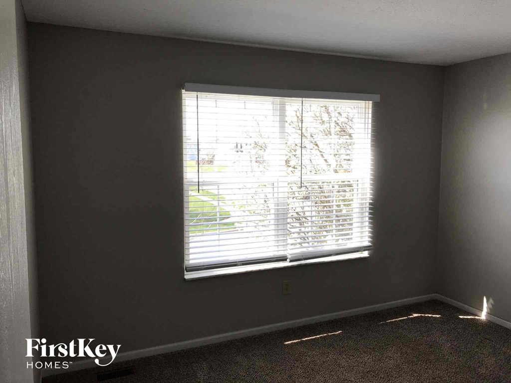 a living room with a window with blinds on it