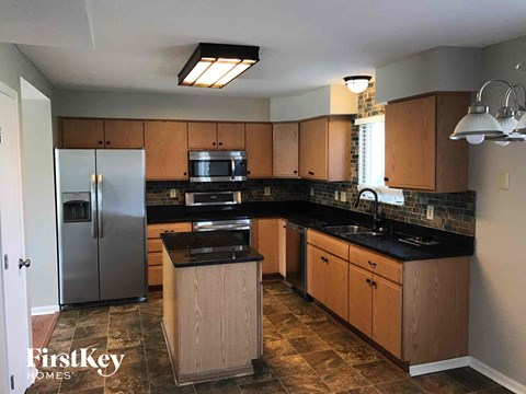 a kitchen with wooden cabinets and a stainless steel refrigerator