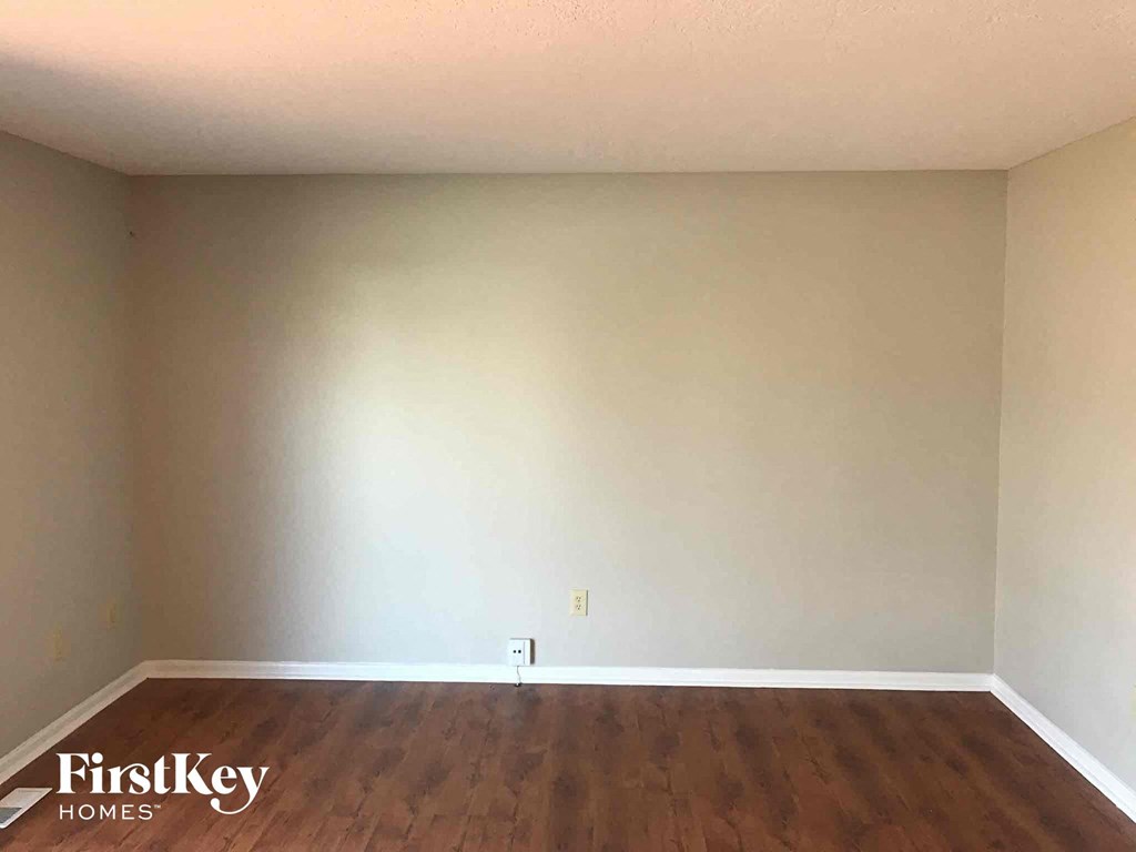 a blank room with white walls and wooden floors