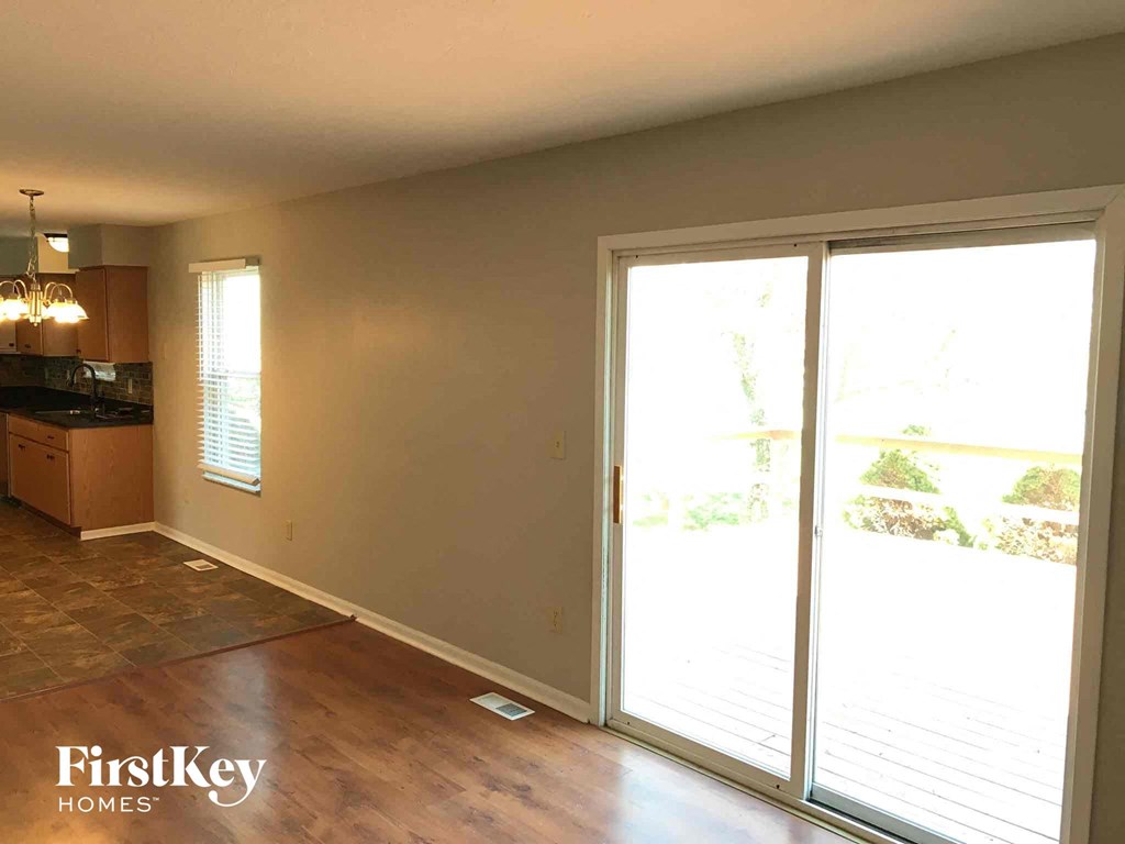 an empty living room with sliding glass doors to a patio