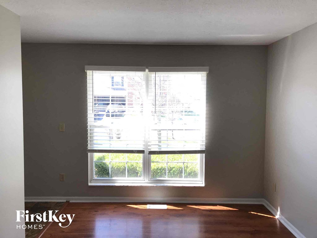 a living room with a window and wood floors