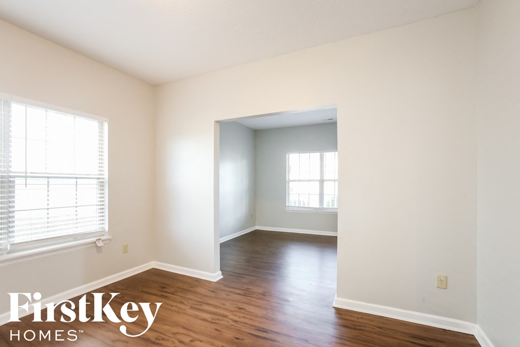 an empty room with a hard wood floor and white walls