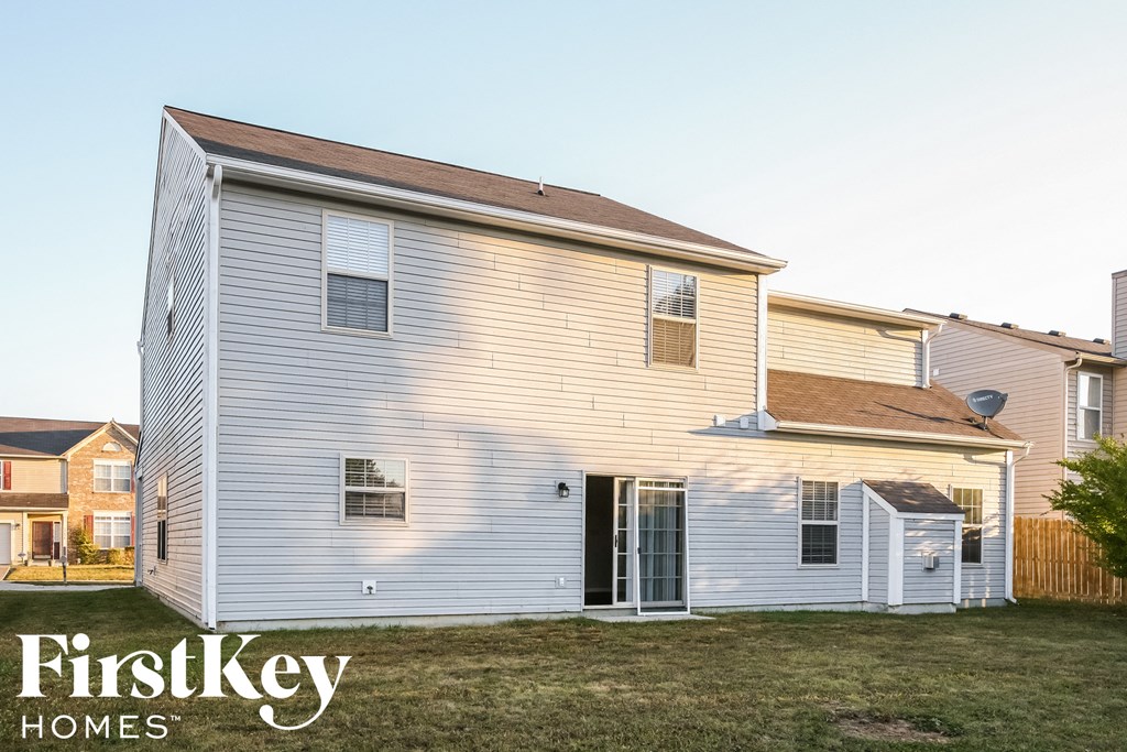 a white house with white siding and a backyard