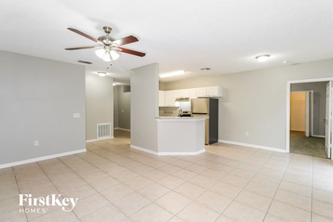 A spacious room with a fan and a counter in the middle.