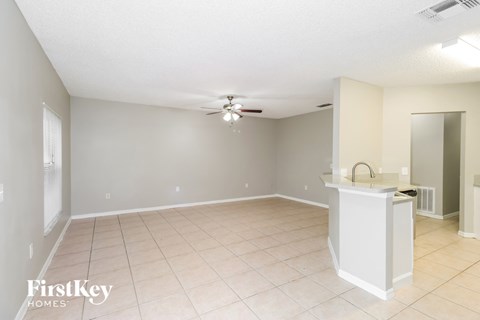 A spacious room with a kitchen island and a ceiling fan.