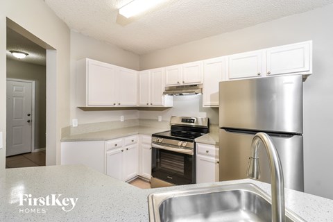 A kitchen with a stainless steel refrigerator and a sink.