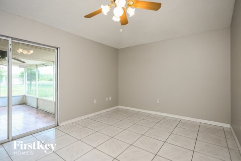 a living room with a ceiling fan and a tiled floor