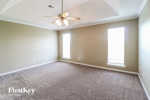 a living room with carpet and a ceiling fan