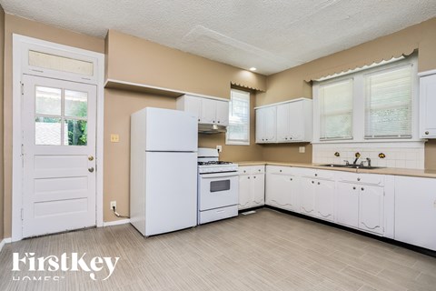 a white kitchen with white appliances and white cabinets