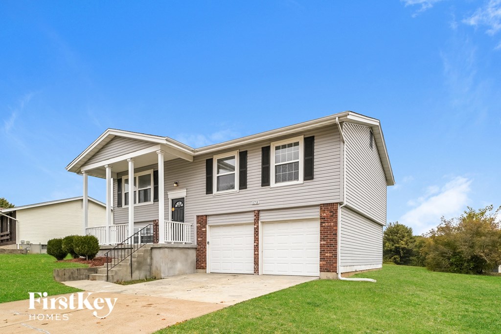a beige house with a driveway and a garage door