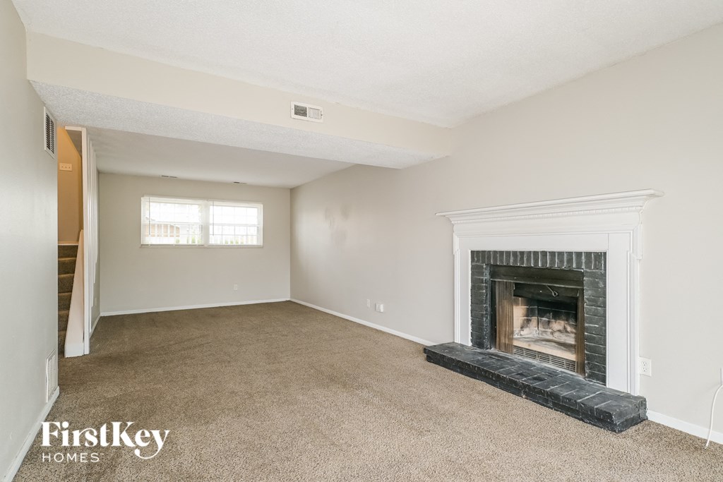 a living room with a fireplace and a carpeted floor