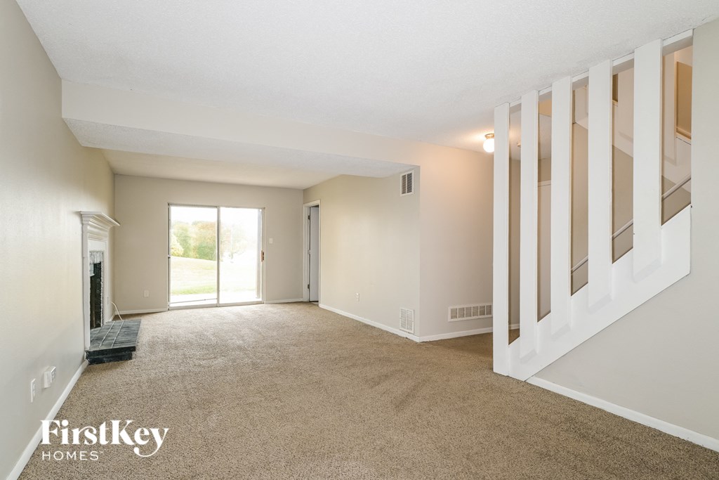 a living room with a fireplace and a carpeted floor