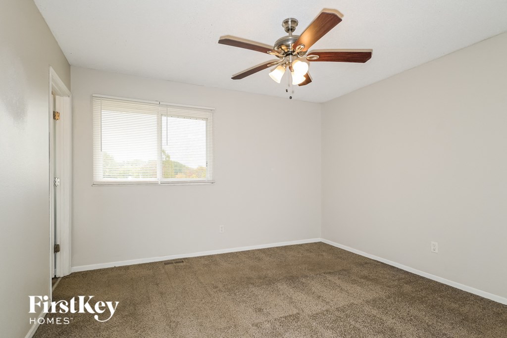 a living room with carpet and a ceiling fan