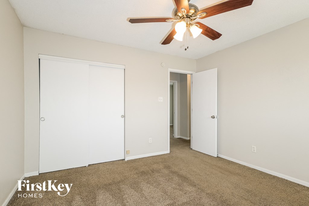 a living room with carpet and a ceiling fan
