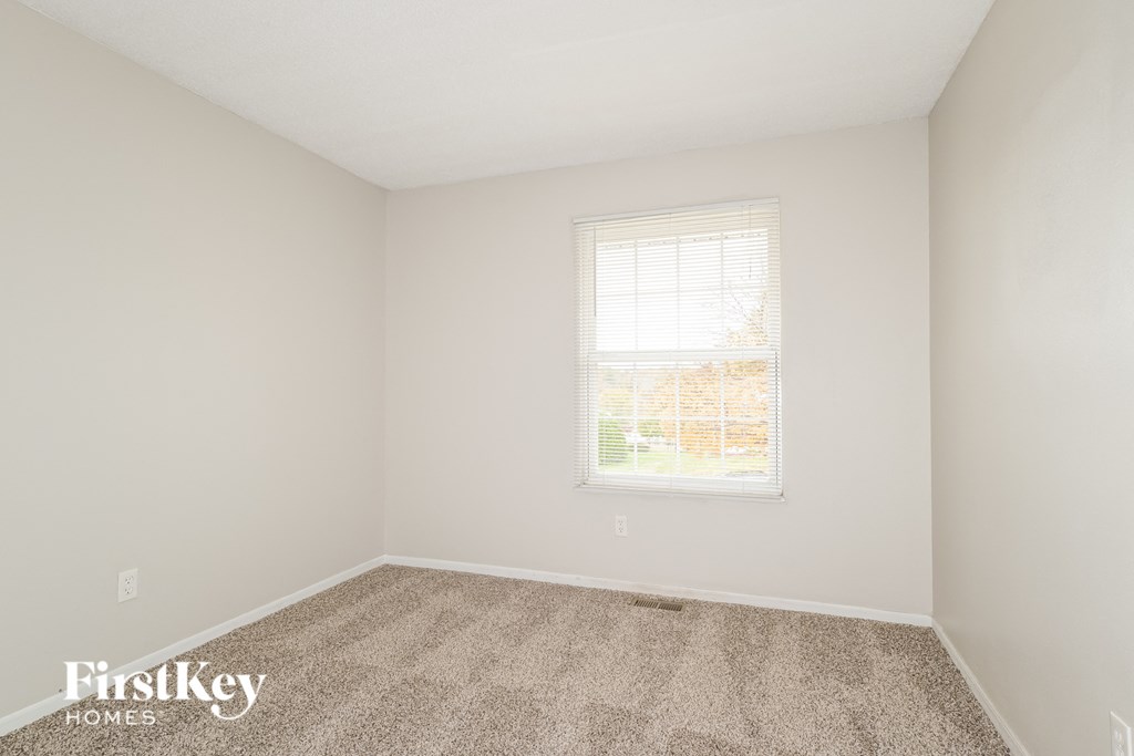 a bedroom with carpet and a window