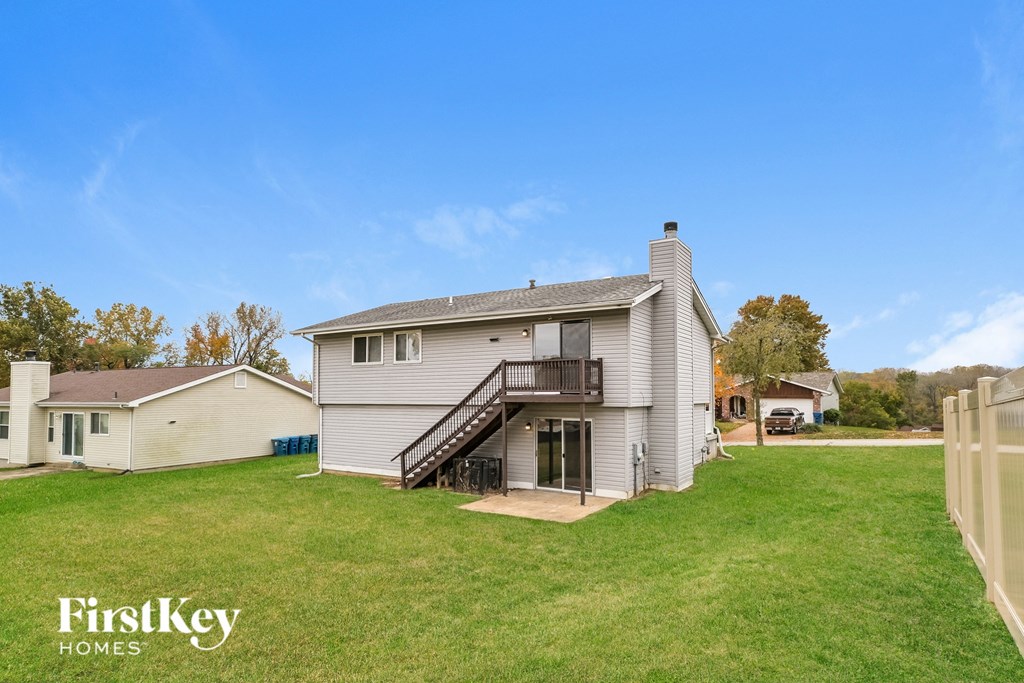 a white house with a yard and a deck