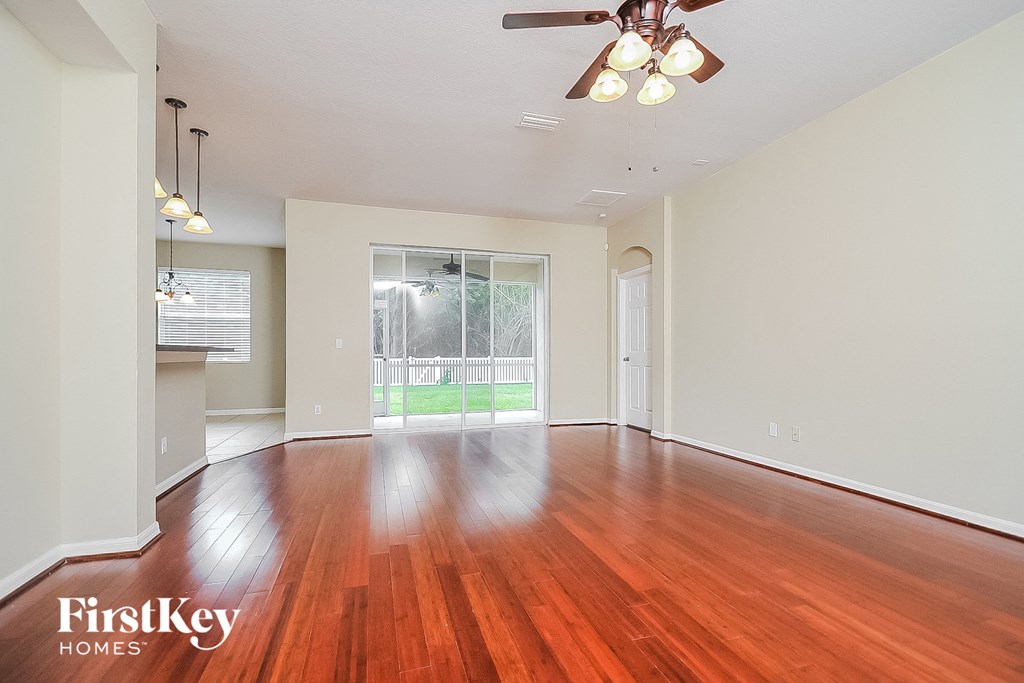 an empty living room with wood flooring and a large window