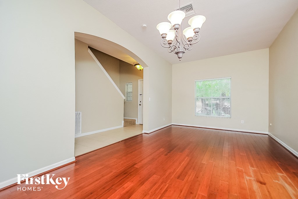 a spacious living room with hardwood flooring and a large window
