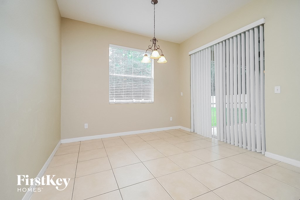 an empty dining room with a sliding glass door to the backyard