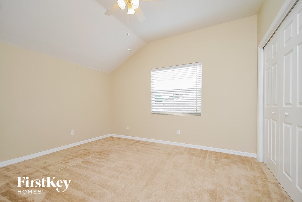 the living room of a home with beige walls and a wooden floor