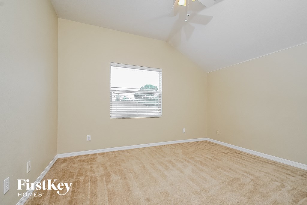 the living room of an empty house with wood floors and a window
