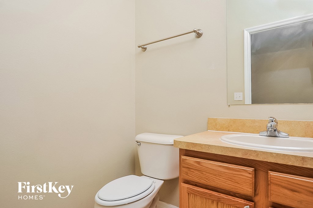 a bathroom with a toilet and a sink and a mirror