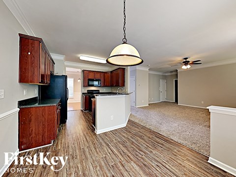 A kitchen with wooden cabinets and a black refrigerator.