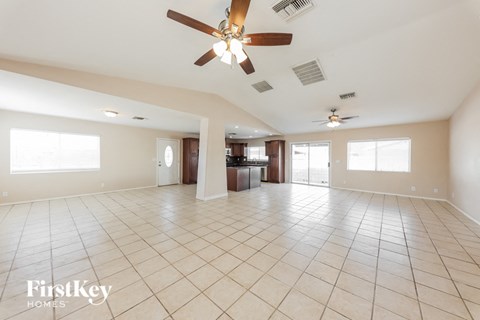 A spacious room with a ceiling fan and tiled flooring.