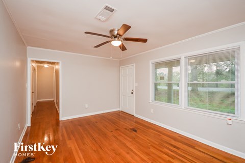 a living room with wood floors and a ceiling fan