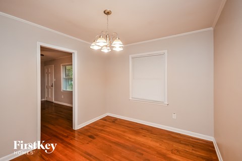 a bedroom with hardwood flooring and a door to a hallway with a window