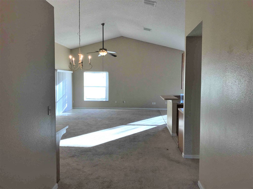 A room with a ceiling fan and a chandelier.