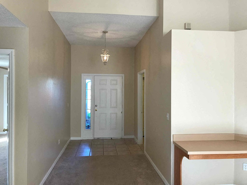 A room with a white door and a light fixture on the ceiling.