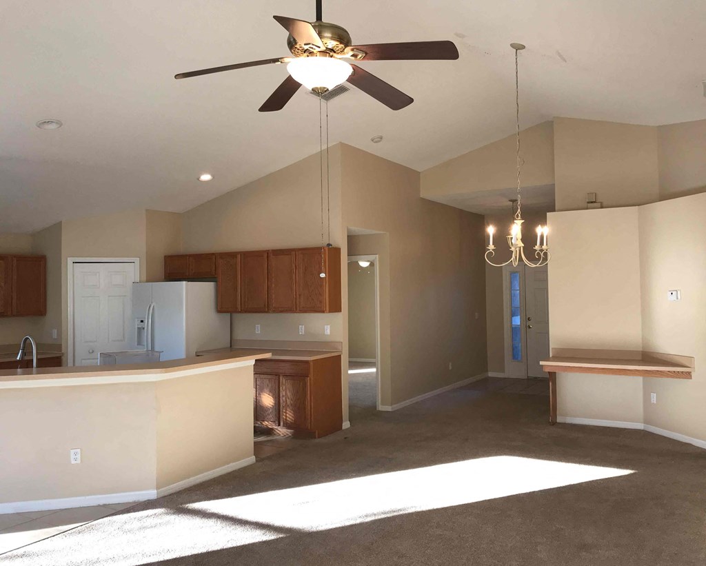 A kitchen with a ceiling fan and a chandelier.