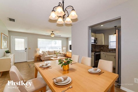 A dining room with a wooden table set for a meal.