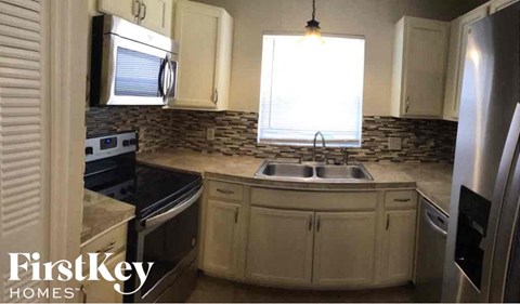 A kitchen with a sink and a refrigerator.