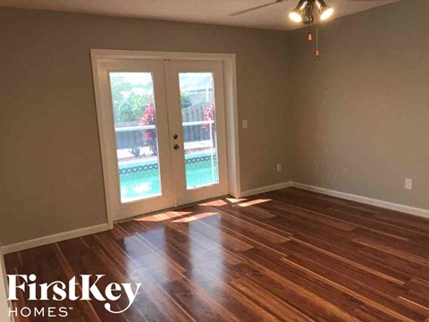 a living room with a hard wood floor and a door to a patio
