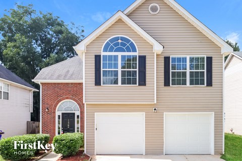 a tan house with a white garage door