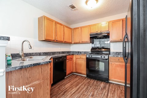 a kitchen with wooden cabinets and black appliances